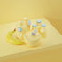 Main image for Ovie LightTag set on stylized all-yellow background. All 6 LightTags are lit up and propped on food containers that are painted pale yellow to match pale yellow background