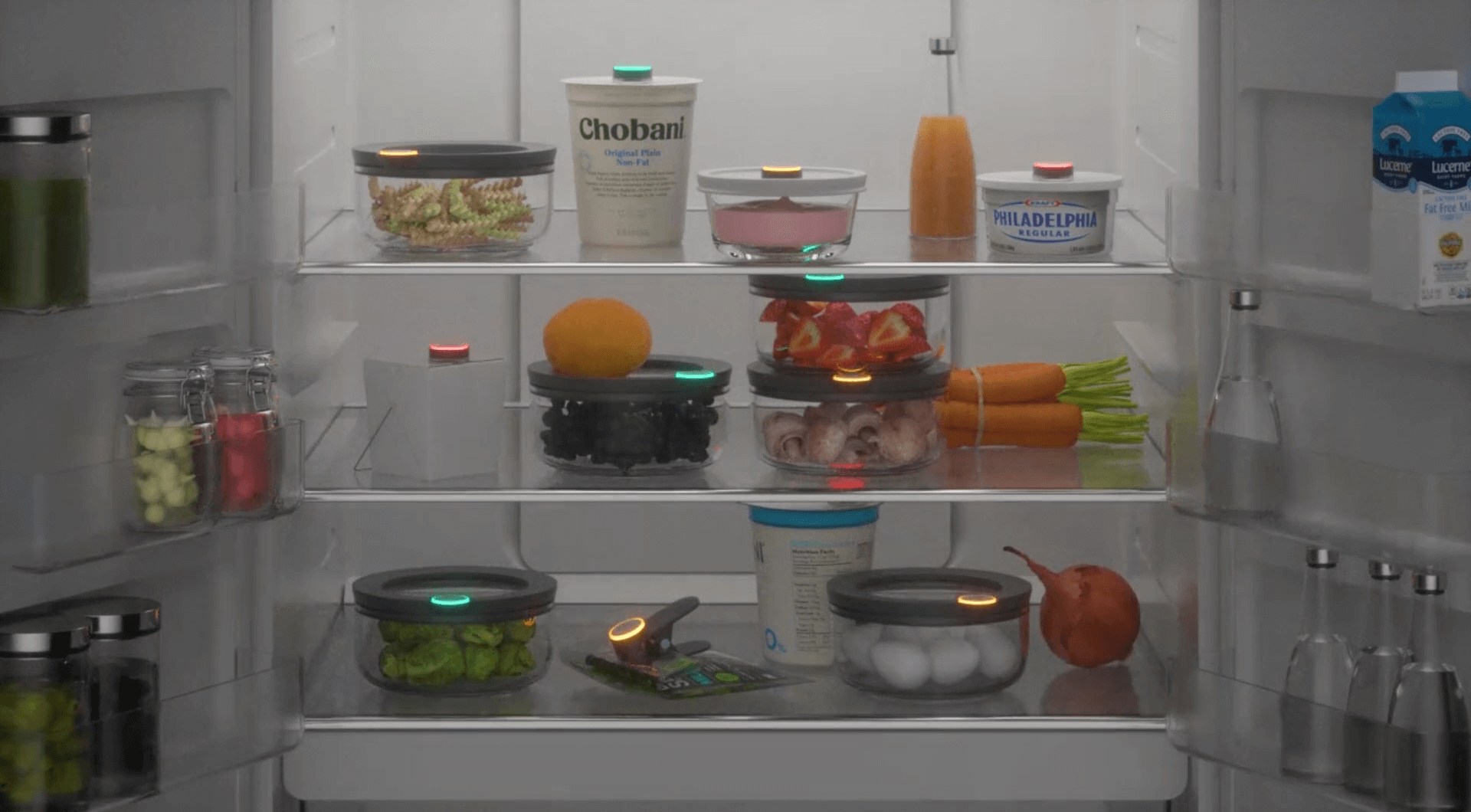 Image of an organized, open refrigerator full of food with Ovie LightTags lit up in different colors-- Teal, yellow, and red-- on various foods