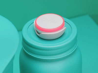 Stylized mostly-teal image focused on jar with Ovie LightTag on top lit up red