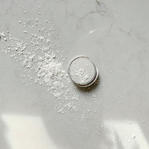 Photo of unlit Ovie LightTag sprinkled with flour on a marble countertop